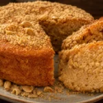 Bolo de paçoca úmido e cheiroso com cobertura de paçoca esfarelada sobre mesa de madeira