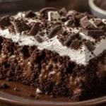 Bolo poke de chocolate cremoso com chantilly, chocolate picado e biscoito triturado sobre mesa de madeira