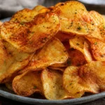 Batata chips crocante e sequinha com páprica e salsinha desidratada em prato rústico