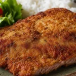 Bife à milanesa crocante com casquinha dourada e carne suculenta sobre mesa rústica