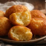 Biscoito de polvilho frito com queijo douradinho e crocante sobre mesa rústica