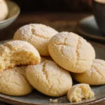 Bolachinhas de nata macias com açúcar refinado sobre mesa rústica, acompanhadas de café