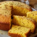Bolo de fubá super fofinho com erva-doce e fatias douradas sobre mesa rústica