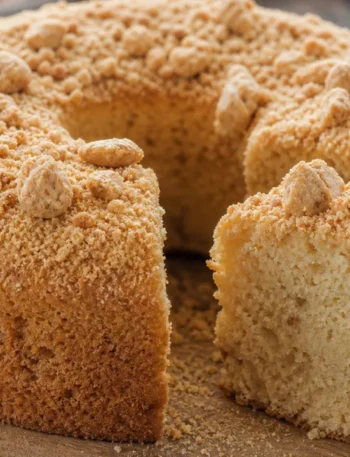 Bolo de paçoca fofinho com paçoca esfarelada por cima sobre mesa de madeira