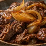 Carne de panela com cebola caramelizada, macia e suculenta, servida em prato rústico