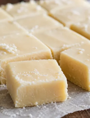 Doce de leite de corte branquinho em pedaços, macio e com textura cremosa sobre papel manteiga