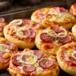 Mini pizza caseira com massa fofinha, molho de tomate, queijo derretido, presunto, calabresa, milho e cebola