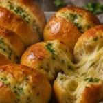 Pão de alho com queijo fofinho, dourado por fora e com queijo derretendo, sobre mesa rústica