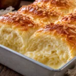 Pão de leite recheado com coco e leite condensado, fofinho e dourado, em forma retangular