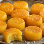Quindim cremoso e brilhante em porções individuais sobre mesa de madeira